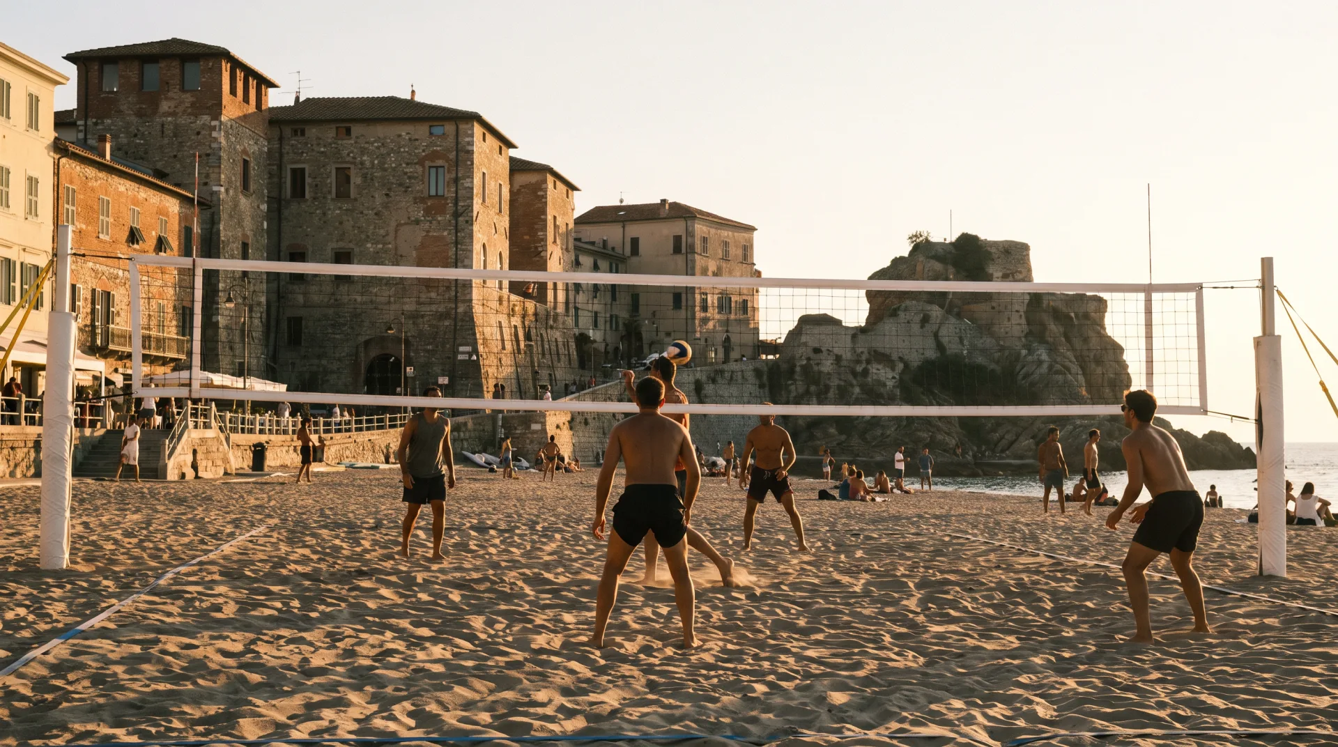 Campo da beach volley regolamentare su una spiaggia cittadina al tramonto, rete bianca e lungomare sullo sfondo