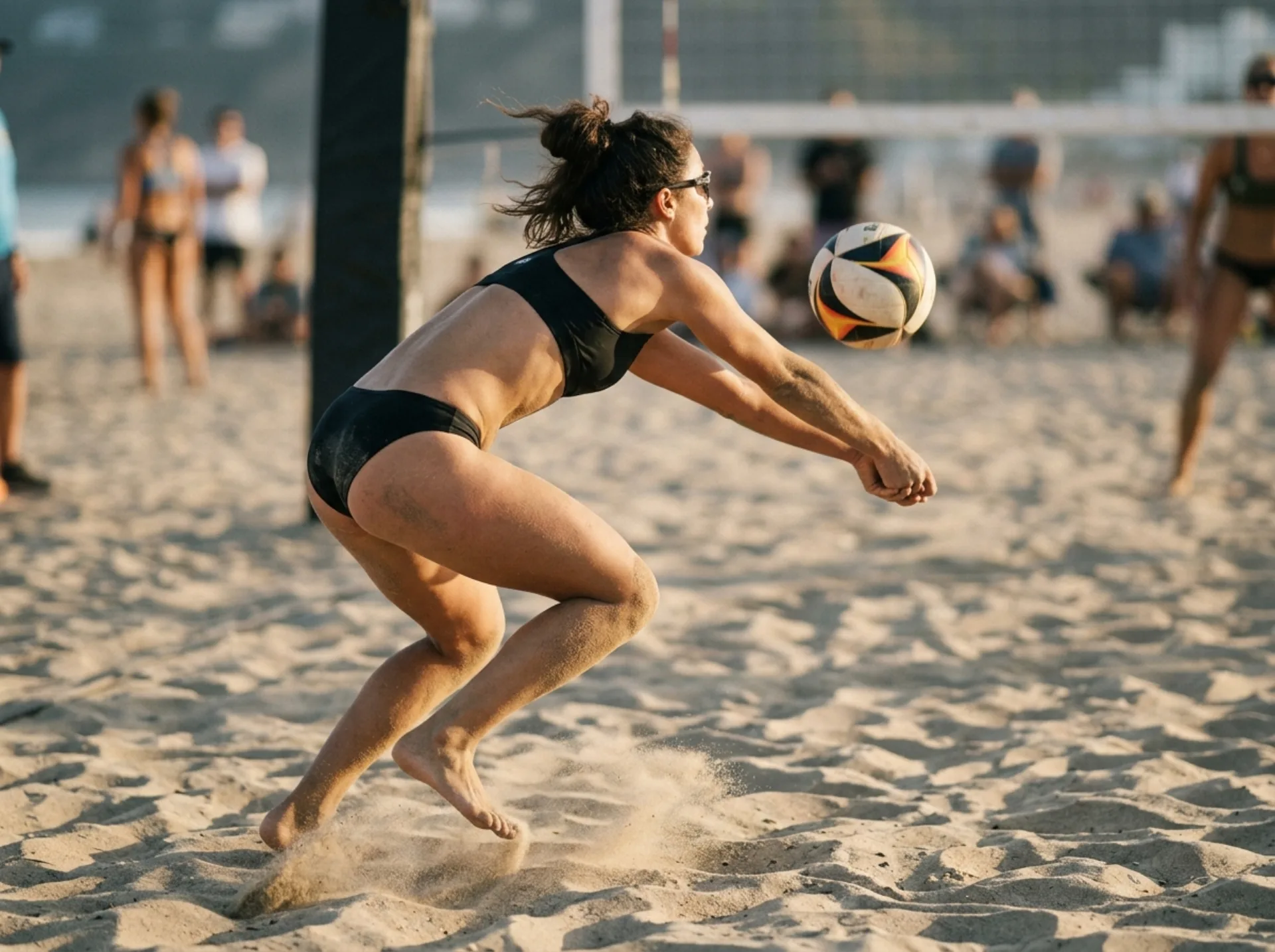 Dettaglio di un bagher basso sulla sabbia durante una partita di beach volley