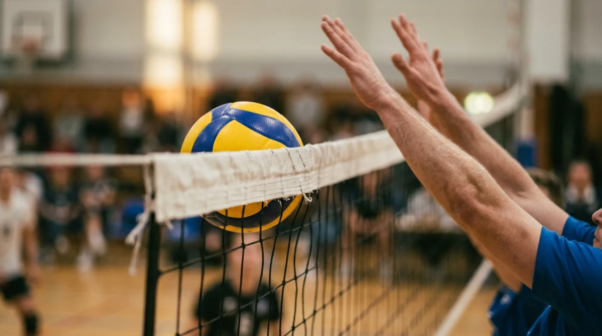 Pallone da pallavolo che tocca il nastro della rete durante una partita indoor