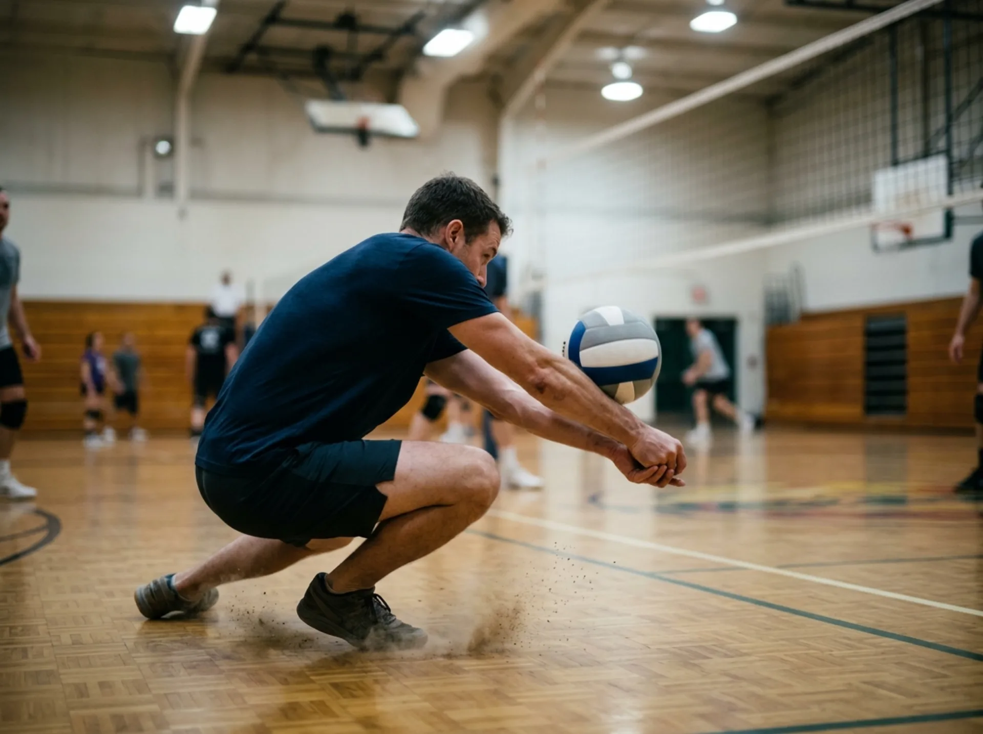 Giocatore in ginocchio che esegue un bagher di ricezione in palestra