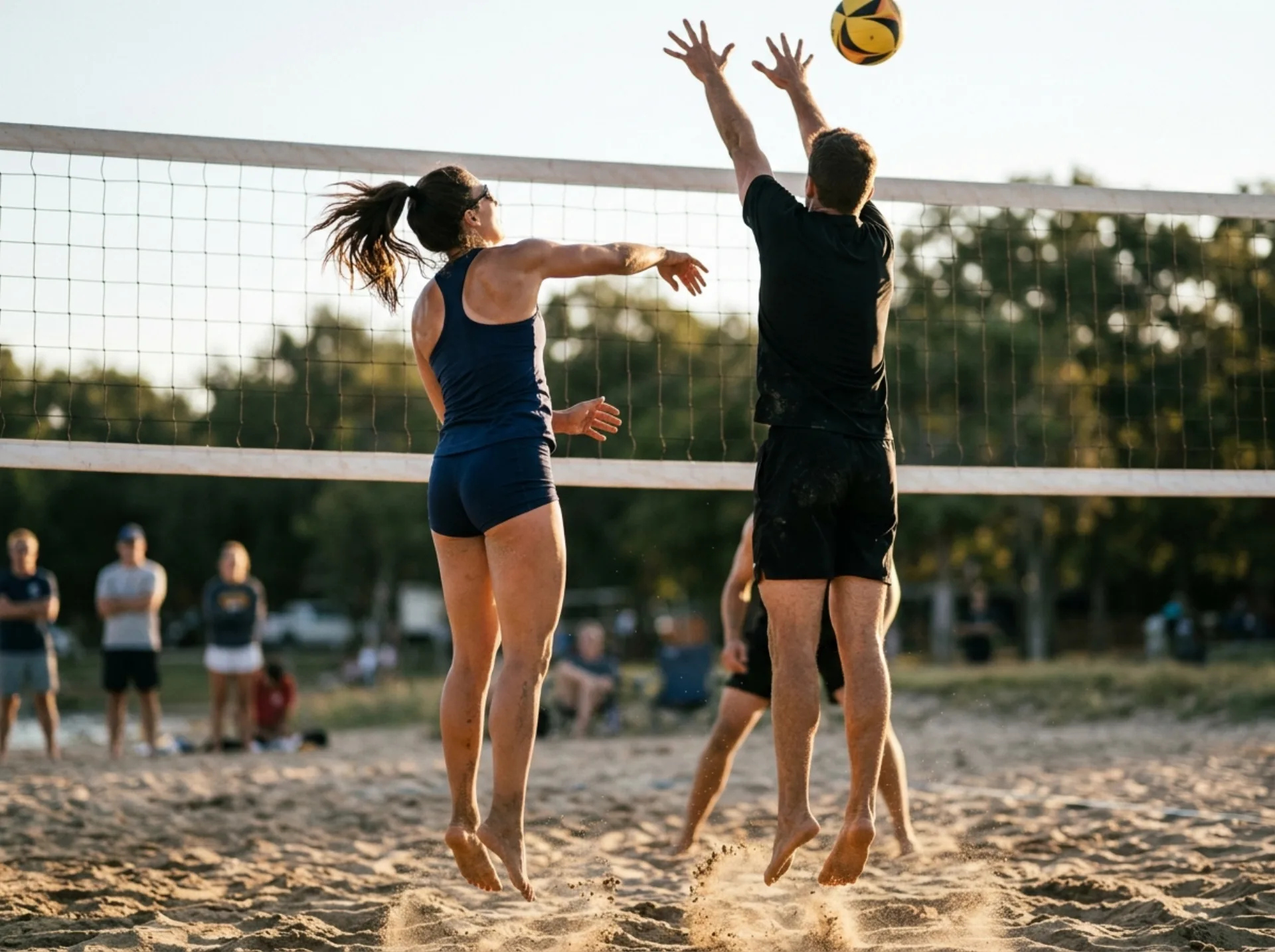 Coppia di giocatori che salta a muro durante una partita di pallavolo mista